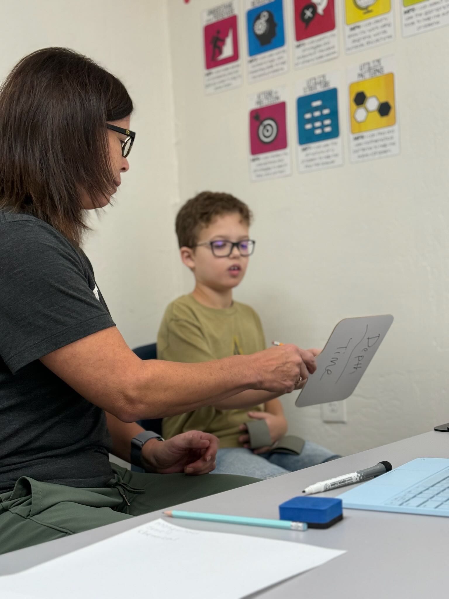 Teacher working with student using whiteboard in classroom