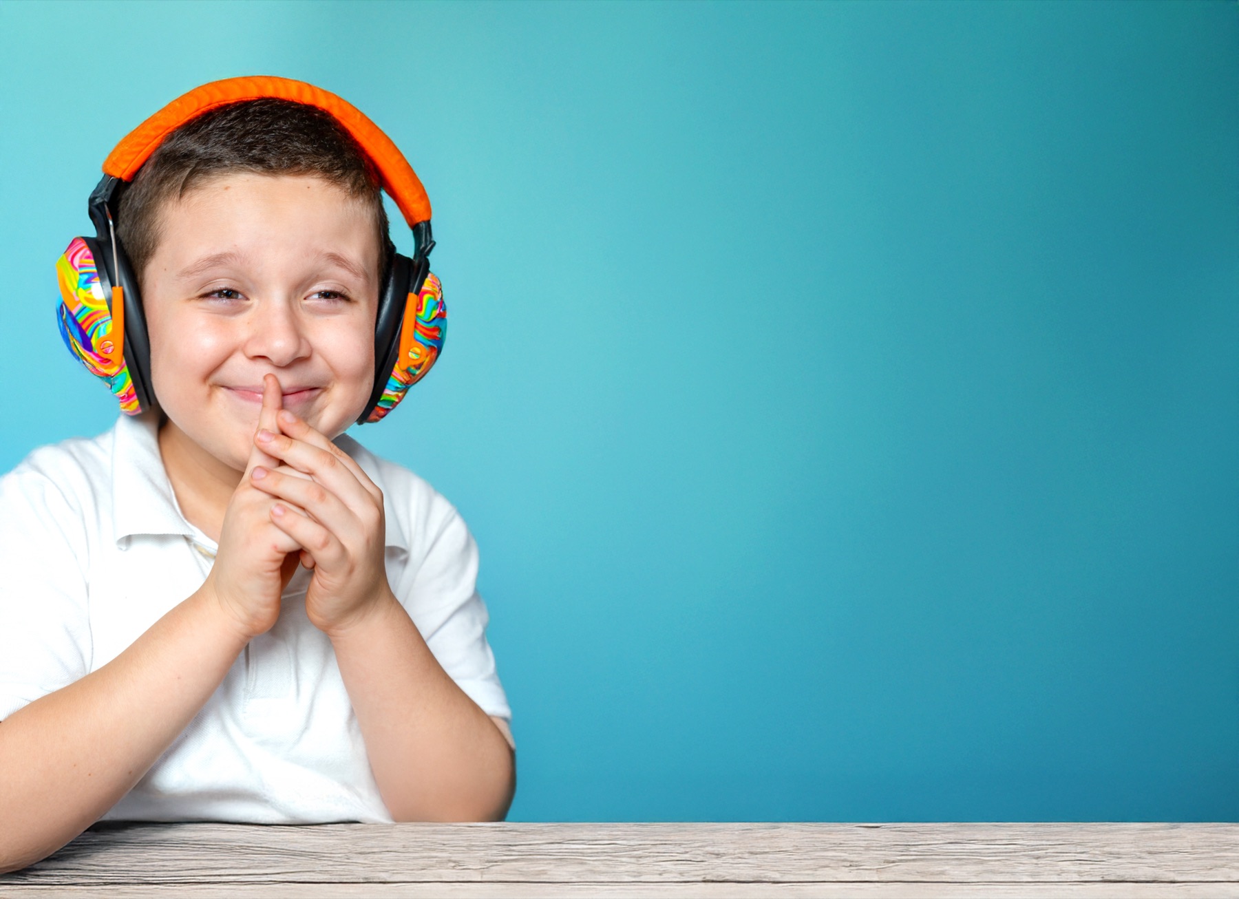 Cheerful student with colorful noise-canceling headphones
